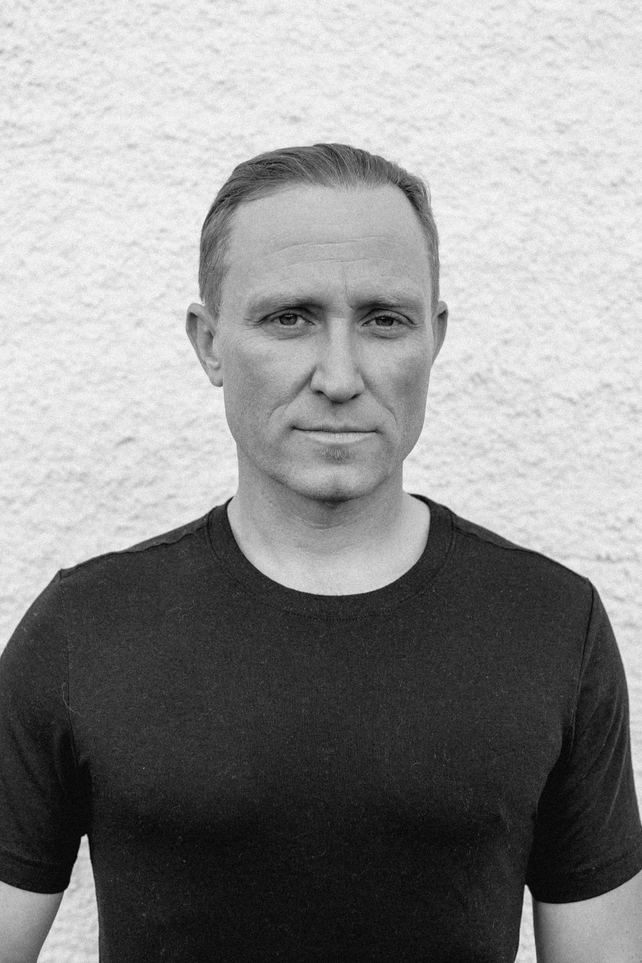 Black and white portrait of Thoryn Stephens against a textured white wall